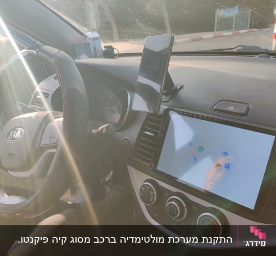 מערכת ניווט ומסך ברכב קיה עם הגה וטלפון נייד